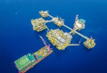 Vista aérea de um complexo de plataformas offshore em alto-mar.