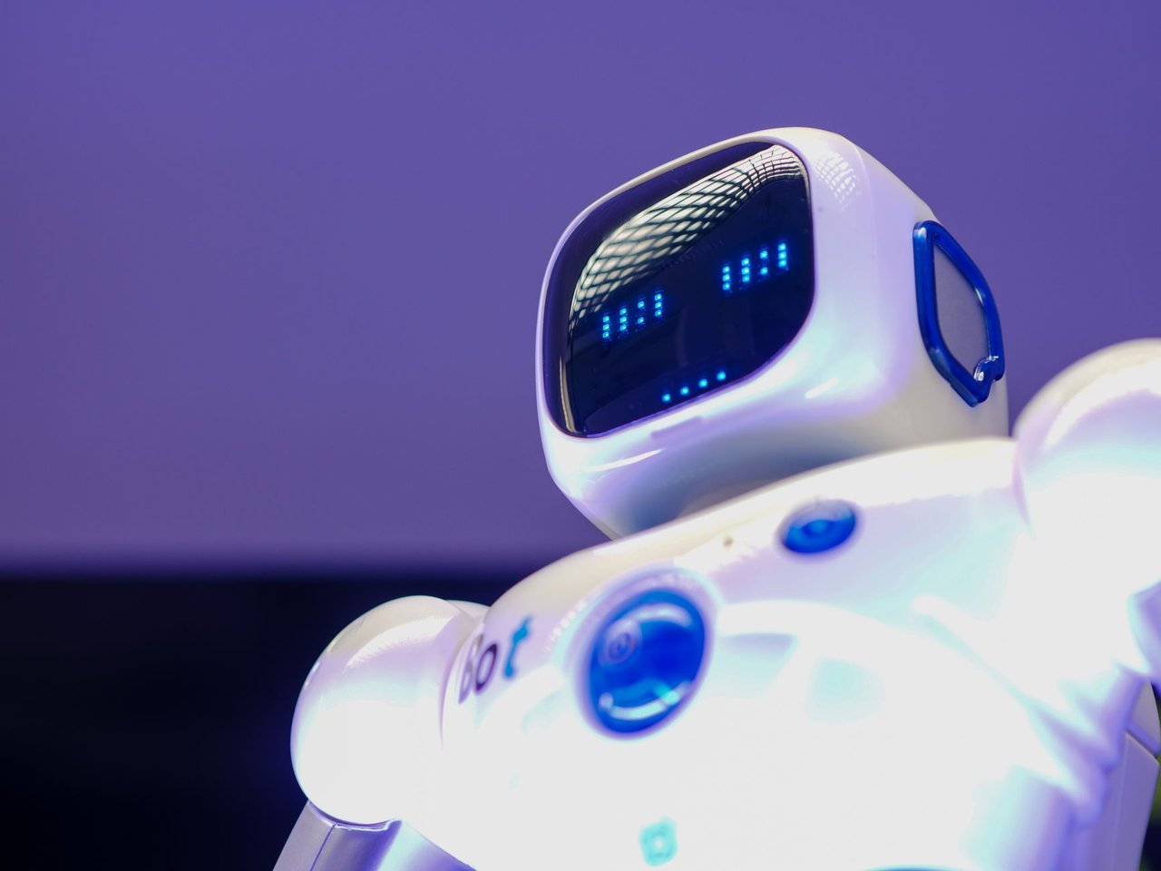 Robô humanoide moderno diante de uma tela luminosa, representando a inteligência artificial e seus avanços tecnológicos.