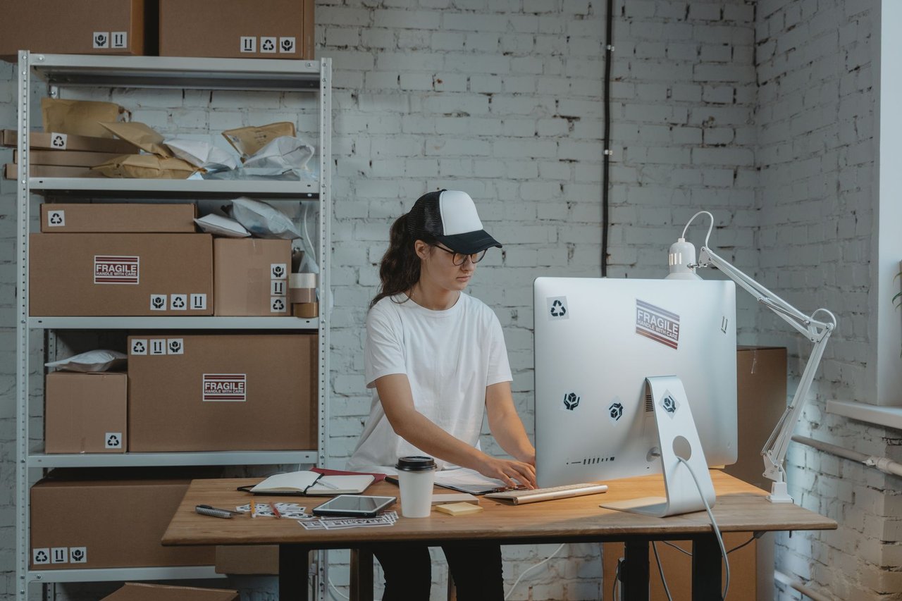 Profissional trabalhando em um computador em um escritório organizado.