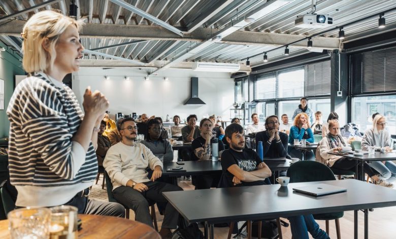 Palestrante apresenta conteúdo a um público diverso durante um workshop em ambiente moderno.